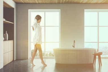 Beyaz banyoda dolabı olan bir kadın.