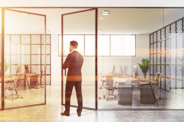 Beyaz ve metal ofisindeki düşünceli iş adamı.