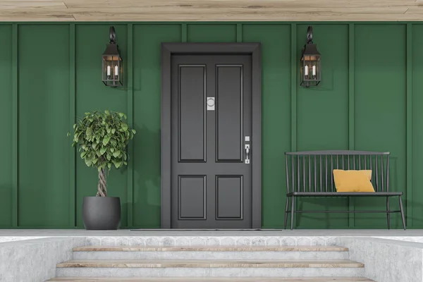 Черная входная дверь зеленого дома, дерева и скамейки — стоковое фото