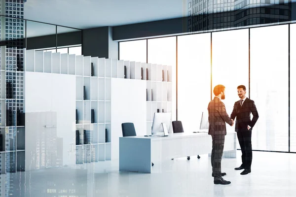 Бизнесмены пожимают руки в белом офисе — стоковое фото