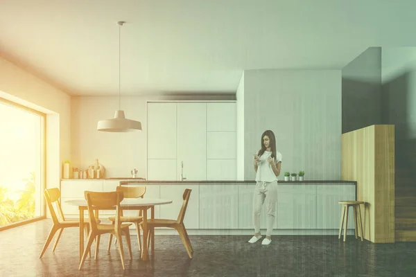 Mujer en cocina blanca y de madera con mesa —  Fotos de Stock