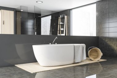 Geniş gri fayanslı banyo köşesi ve küveti.