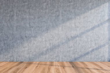 Beton duvarı ve ahşap zemini olan boş bir oda.