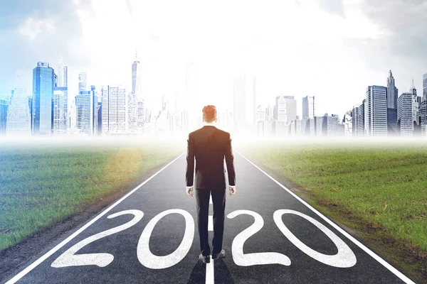 Affärsman står på 2020 väg — Stockfoto