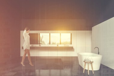 Siyah beyaz banyoda yürüyen bir kadın.