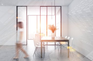 Beyaz yemek odasında yürüyen kadın