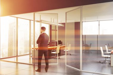 Gri ofis salonundaki genç işadamı