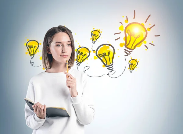 Mujer con cuaderno y sus brillantes ideas — Foto de Stock