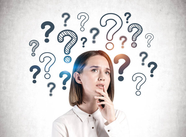 Задумчивая молодая бизнесвумен, вопросительные знаки

