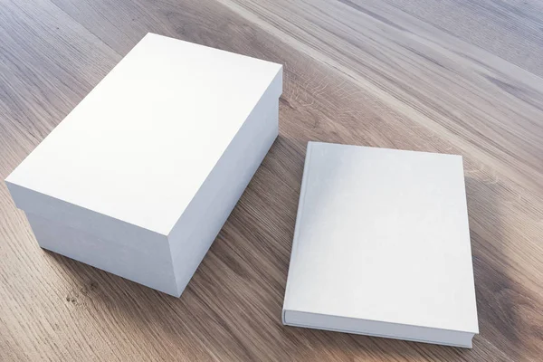Caja de regalo blanca cerrada y libro en la mesa — Foto de Stock