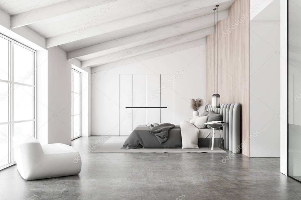 Attic white and wooden bedroom with armchair