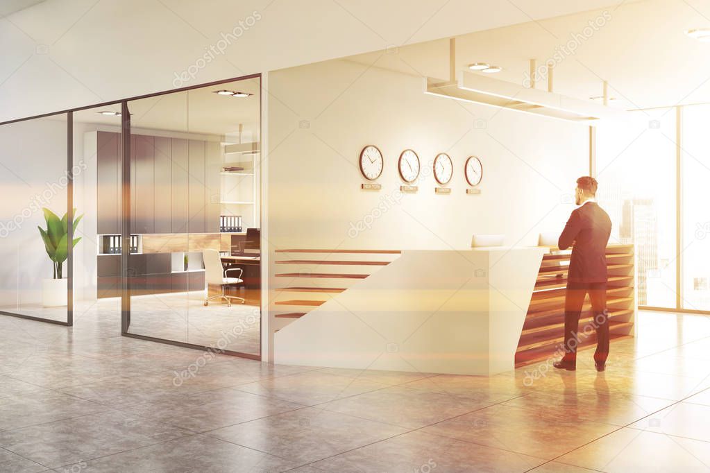 Businessman in white office with reception