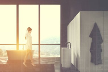 Çatı katında yürüyen siyah beyaz bir kadın.