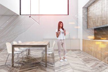 Beyaz mutfakta, tahta masalı bir kadın.