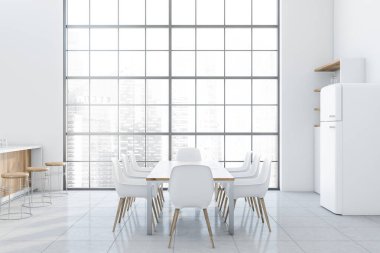 Buzdolabı ve yemek masası olan beyaz mutfak.