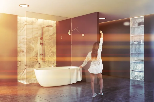 Woman in gray bathroom with tub and shower — Stockfoto