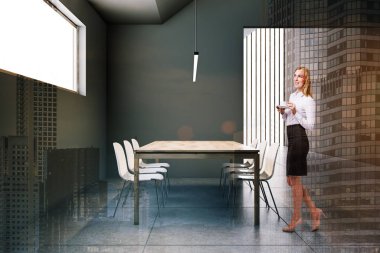 Gri tavan arası yemek odasında sarışın bir kadın.