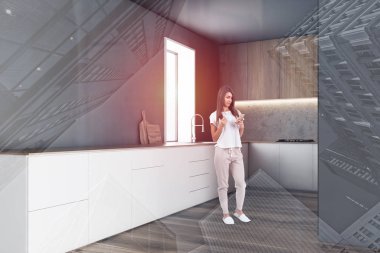 Gri mutfakta beyaz tezgahlı bir kadın.