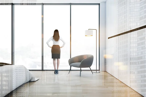 Vrouw in witte slaapkamer met fauteuil — Stockfoto
