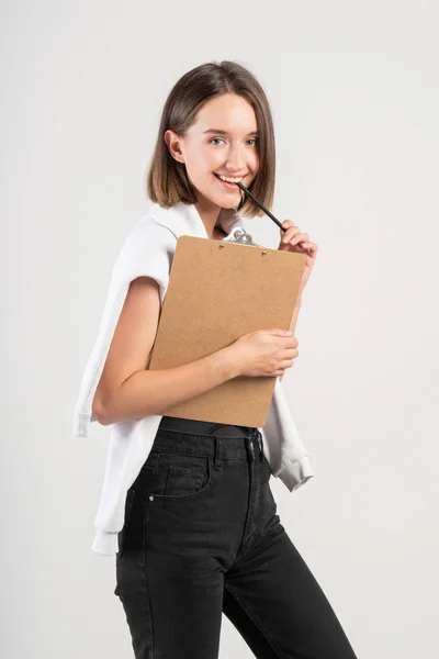 Mosolygós tini lány írótáblával és ceruzával — Stock Fotó
