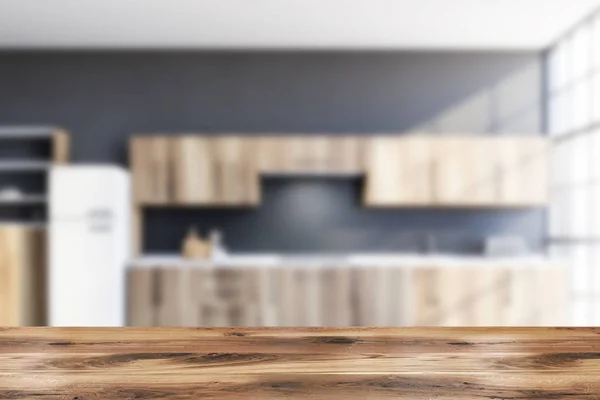 Mesa em cozinha cinza embaçada com geladeira — Fotografia de Stock