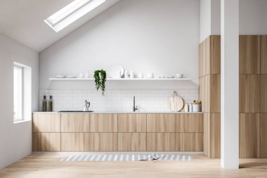 Tavan arası beyaz mutfak içi tezgahlarla dolu.