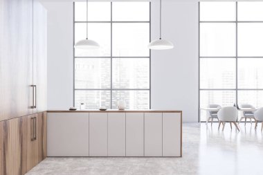 Tezgahı ve masası olan panoramik beyaz mutfak.