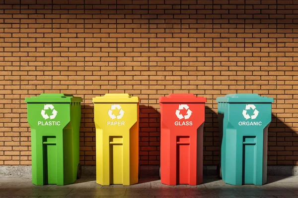 Row of colorful recycle bins near brick wall