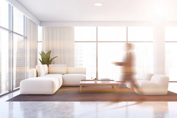 Homem andando na sala de estar branca com sofá — Fotografia de Stock