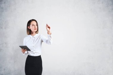 Tablet yazısıyla ciddi bir iş kadını.