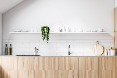 Ahşap tezgahlı beyaz tavan arası mutfağı.