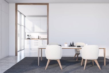 Koltukları ve mutfağı olan beyaz yemek odası.