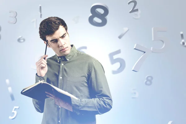 Homem atencioso com caderno e números — Fotografia de Stock