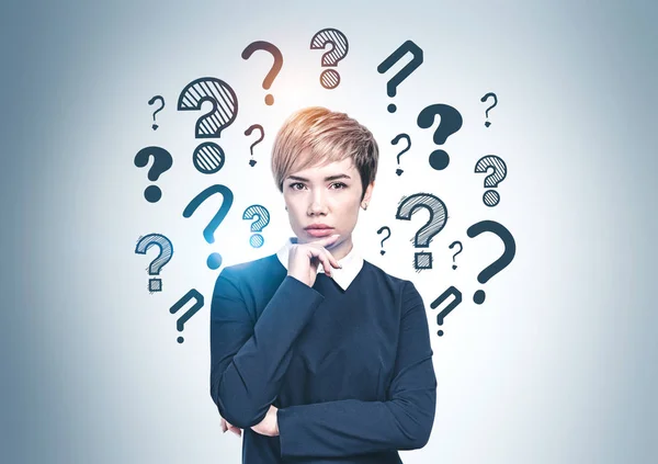 Thoughtful Asian businesswoman, question marks — Stock Photo, Image