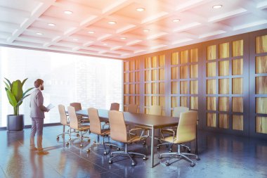 Gri panoramik konferans salonunun köşesindeki CEO.