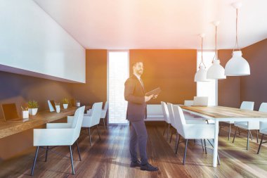 Toplantı masası olan gri açık uzay ofisindeki adam.