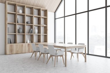 Kitaplığı olan beyaz tavan arası yemek odası.