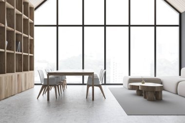 Kitaplığı ve kanepesi olan gri tavan arası yemek odası.