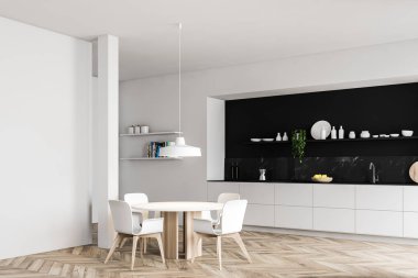 Yemek masası olan siyah ve beyaz mutfak köşesi.