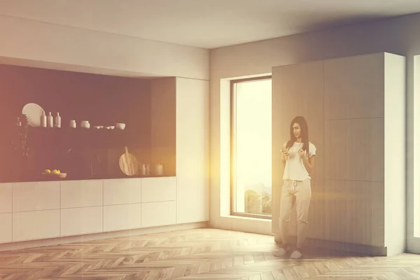 Mulher na cozinha branca e preta com armário — Fotografia de Stock