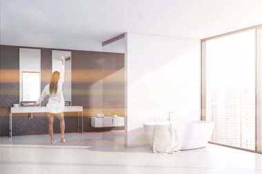 Panoramik gri ve beyaz banyodaki kadın.