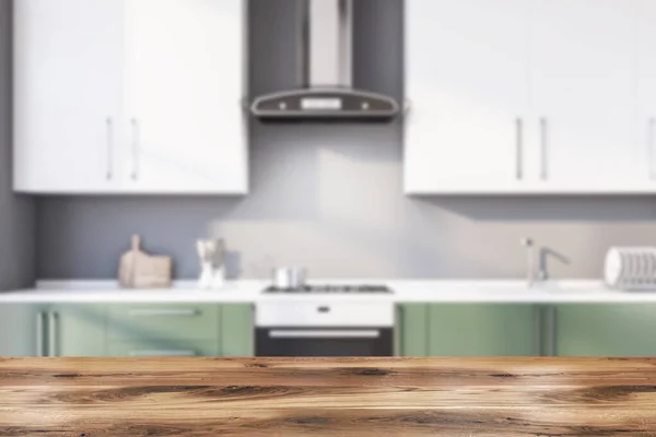 Tafel in wazig grijze keuken met aanrecht — Stockfoto