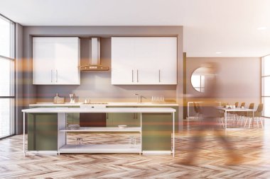 Gri ve yeşil mutfakta yürüyen adam