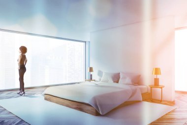 Lüks beyaz yatak odasındaki kadın.