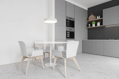 Fırınları ve yuvarlak masaları olan gri mutfak köşesi