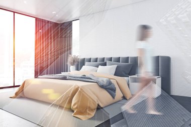 Beyaz panoramik yatak odasında yürüyen bir kadın