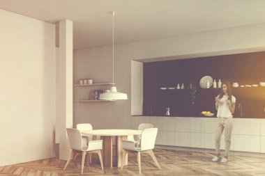 Kahveli kadın beyaz ve siyah mutfakta.