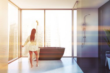 Küveti ve duşu olan beyaz banyodaki kız.