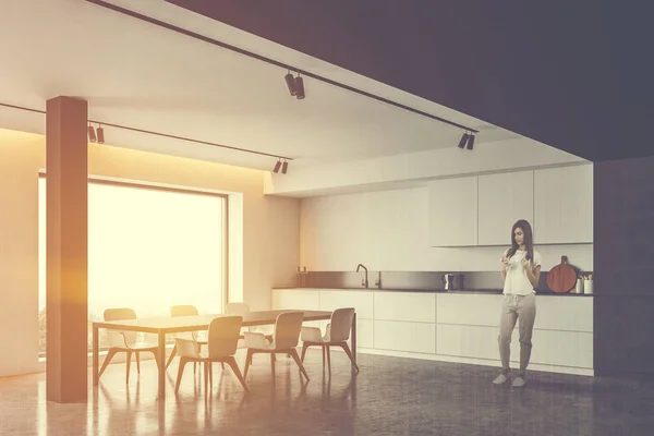 Woman in sunlit kitchen with table — 스톡 사진