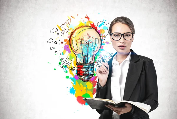 Businesswoman with notebook and her bright idea — Stock Photo, Image